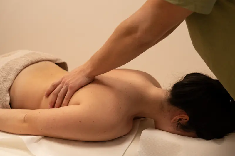 A close view of hands performing a shoulder and back massage.